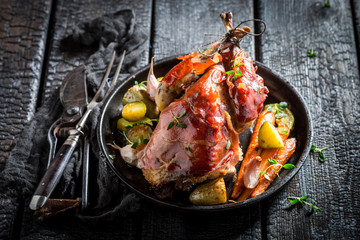 Fresh pheasant with bacon and spices on dark background