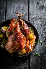 Poster Grilled pheasant with bacon and vegetables on dark background © shaiith