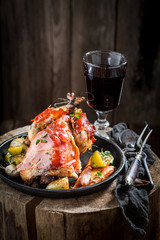 Roasted pheasant with bacon and vegetables on dark background