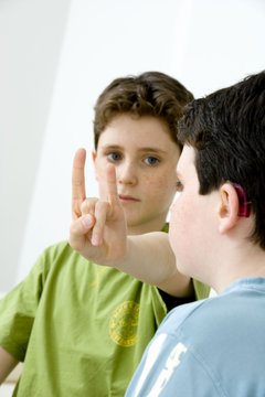 Models Do not use for HIV Young boy using the French sign language to discuss with his hearing-impaired brother The French sign language uses signs to designate words but also dactylology (each letter of the alphabet is represented by a defined position of the fingers then enabling to spell a word) and the lip reading The young boy designates the letter \h\ (see image nﾰ0833202 ans series of images from nﾰ0572308 to 0574108 to see the other letters of the alphabet)