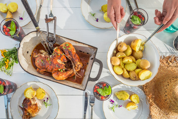 Family dinner with chicken and potatoes on white table
