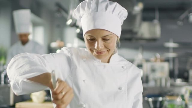 In a Famous Restaurant Female Chef Prepares Food. She Works in a Big Modern Kitchen. Shot on RED EPIC-W 8K Helium Cinema Camera.