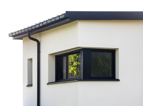 Dunkles Eckfenster aus Aluminium an einem modernen Wohnhaus mit Flachdach – Dark Corner window made of Aluminium on a modern residential house with flat roof