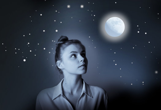 Young slim woman is looking at full moon