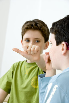 Models Do not use for HIV Young boy using the French sign language to discuss with his hearing-impaired brother The French sign language uses signs to designate words but also dactylology (each letter of the alphabet is represented by a defined position of the fingers then enabling to spell a word) and the lip reading The young boy designates the letter \a\ (see image nﾰ0833202 ans series of images from nﾰ0572308 to 0574108 to see the other letters of the alphabet)