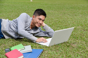 Young male college student sitting use laptop at campus 