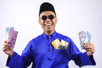 Man in traditional clothing cheerful with money packet during celebrate Eid Fitr.