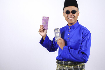 Man in traditional clothing cheerful with money packet during celebrate Eid Fitr.