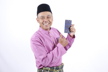Man in traditional clothing cheerful with money packet during celebrate Eid Fitr.