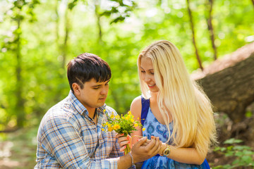 Obraz premium Young man giving a flower dandelion to girlfriend outdoors