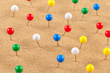 Group of thumbtacks pinned on corkboard