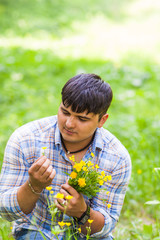 Young man picking up flowers for his woman