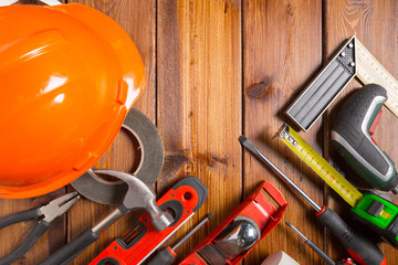 Assorted work tools on wood background