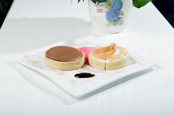 Delicious little cakes with strawberries and cocolate in white wood