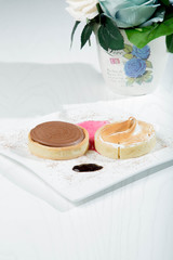 Delicious little cakes with strawberries and cocolate in white wood