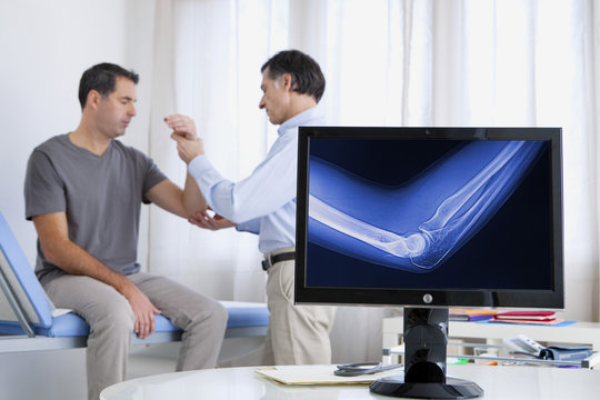 Doctor examining patient's elbow