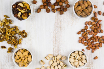 Four bowls with nuts on a  wooden table