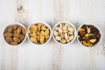 Four bowls with nuts on a  wooden table