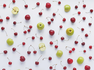 Fototapeta na wymiar Cherries and green apples, plums, isolated on white background. Pattern of cherry with green apples. Abstract food background. Berries and fruit top view.