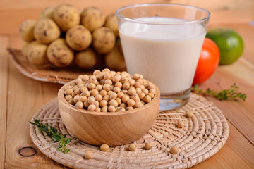 soybean in wooden bowl and a glass of soy milk on wooden table
