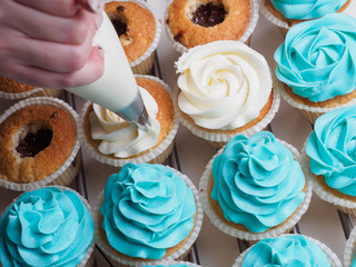 Baking cupcakes. Making cream head by pastry bag