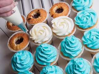 Baking cupcakes. Making cream head by pastry bag