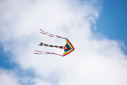 Rainbow kite flying in a cloudy sky