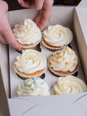 Girl puts cupcakes on paper box