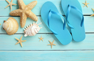 summer equipment, flip flops on wooden board and seashells
