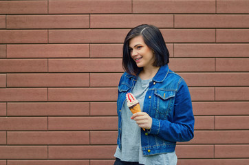 Young cute girl holding an ice cream cone with jam in her hand