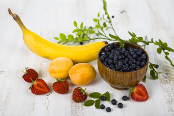 Blueberries in a wooden bowl and fruits