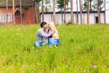 Happy young couple relaxing on the lawn in a summer park. Love concept. Vacation.