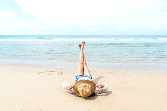 Fashion woman relax on the beach. White sand, blue cloudy sky and crystal sea of tropical beach.