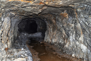 an abandoned mine tunnel in the mountains, stone catacombs. In an abandoned water tunnel
