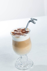 Glass of cold latte coffee topic cocolate cream on isolated white background with desserts