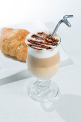 Glass of cold latte coffee topic cocolate cream on isolated white background with desserts