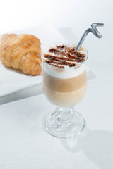 Glass of cold latte coffee topic cocolate cream on isolated white background with desserts