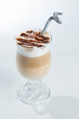 Glass of cold latte coffee topic cocolate cream on isolated white background with desserts