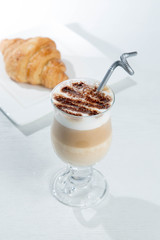 Glass of cold latte coffee topic cocolate cream on isolated white background with desserts