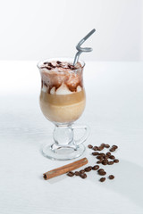 Glass of cold latte coffee topic cocolate cream on isolated white background with desserts
