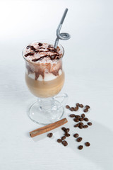 Glass of cold latte coffee topic cocolate cream on isolated white background with desserts