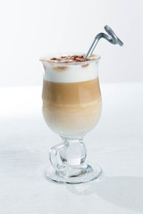 Glass of cold latte coffee topic cocolate cream on isolated white background with desserts