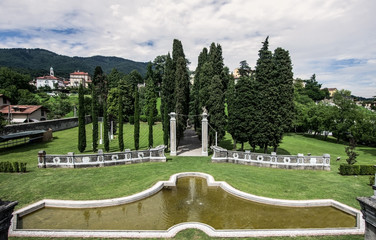 Public garden with large fountain and tree lined avenue