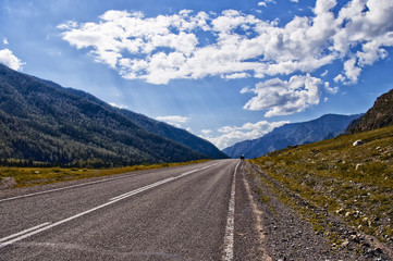 Chuiski road, Altai Republic. The road in the mountains, highway, paved road near the shore of the river Chuya. Sunny day in summer. Biking, cycling, cyclist.