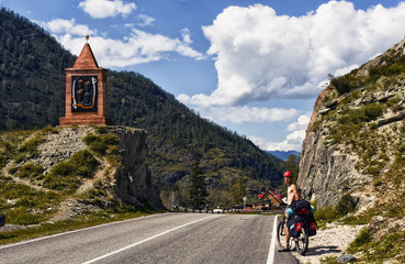 Fototapeta premium Chuiski road, Altai Republic. The road in the mountains, highway, paved road near the shore of the river Chuya. Sunny day in summer. Biking, cycling, cyclist.
