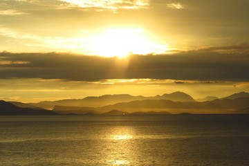 sunrise sunset over sea with distant coastline