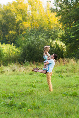 A couple in love beautiful young men and woman hugging in a summer park on a sunny day