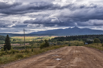 Fototapeta na wymiar Ural mountains, bad weather, approaching thunderstorm, storm, Country Road, Ridge Tulymsky Kamen, village