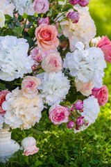 Vintage vase with roses and Hydrangea, eucalyptus bouquet outdoor on the grass