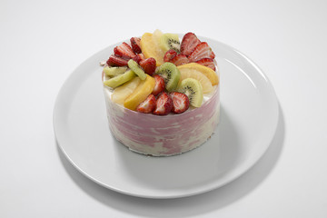 Whole cake with fruits such as strawberry, pineapple and kiwi isolated on white background.